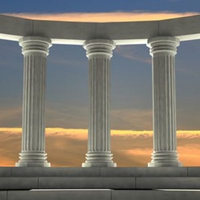 Ancient marble pillars in elliptical arrangement with orange sky